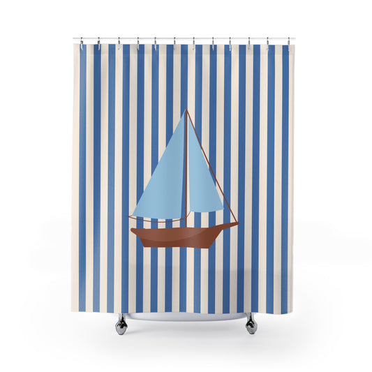 A shower curtain featuring a vertical blue and white stripe pattern with a central illustration of a sailboat with light blue sails and a brown hull, shown hanging from silver hooks against a white background.