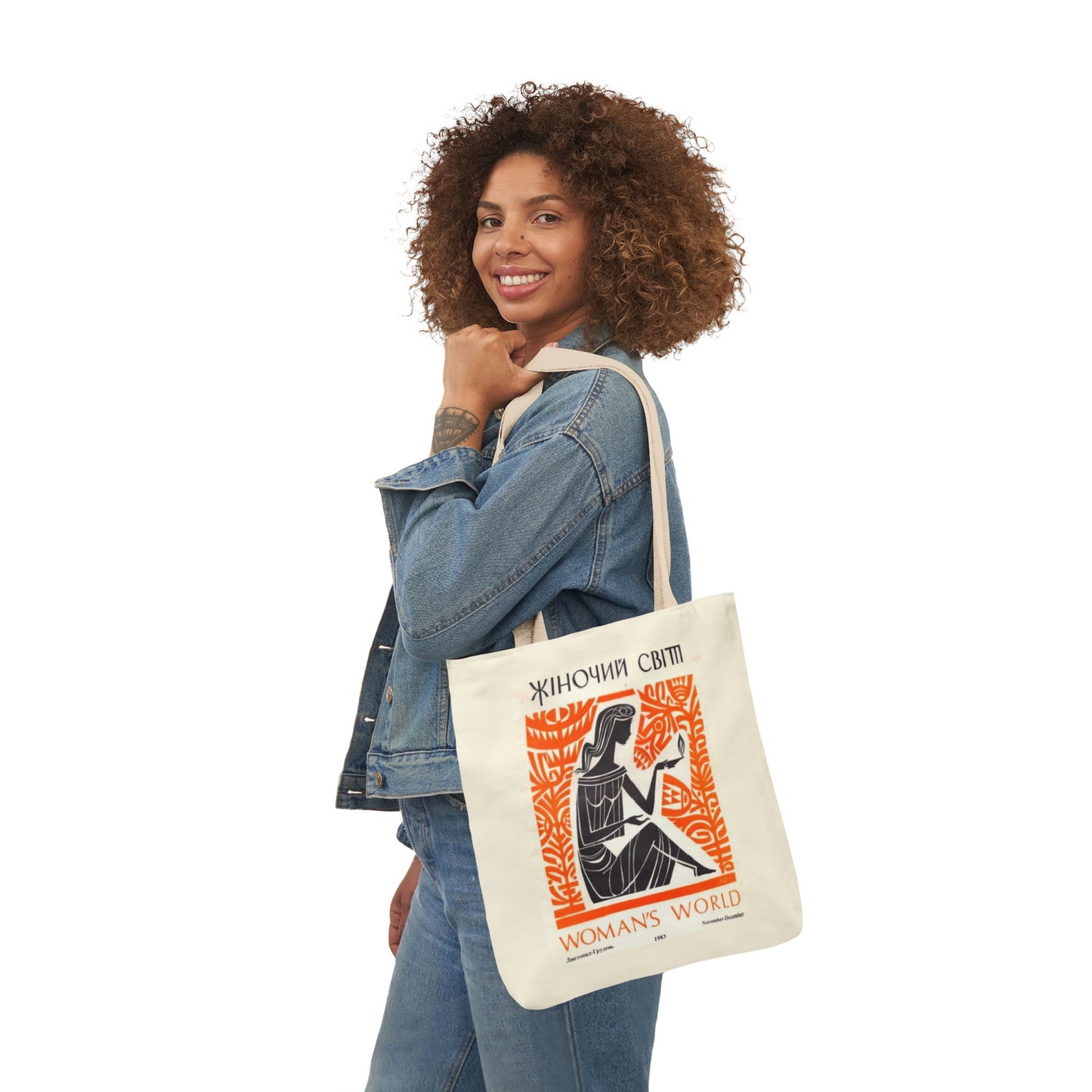 Woman holding a tote bag with a graphic design on a white background