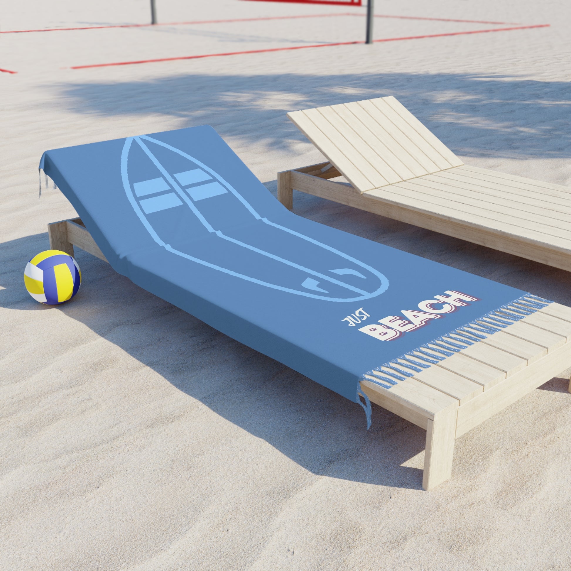 Blue beach towel with paddleboard design and 'Beach' text on a wooden lounge chair in sand.