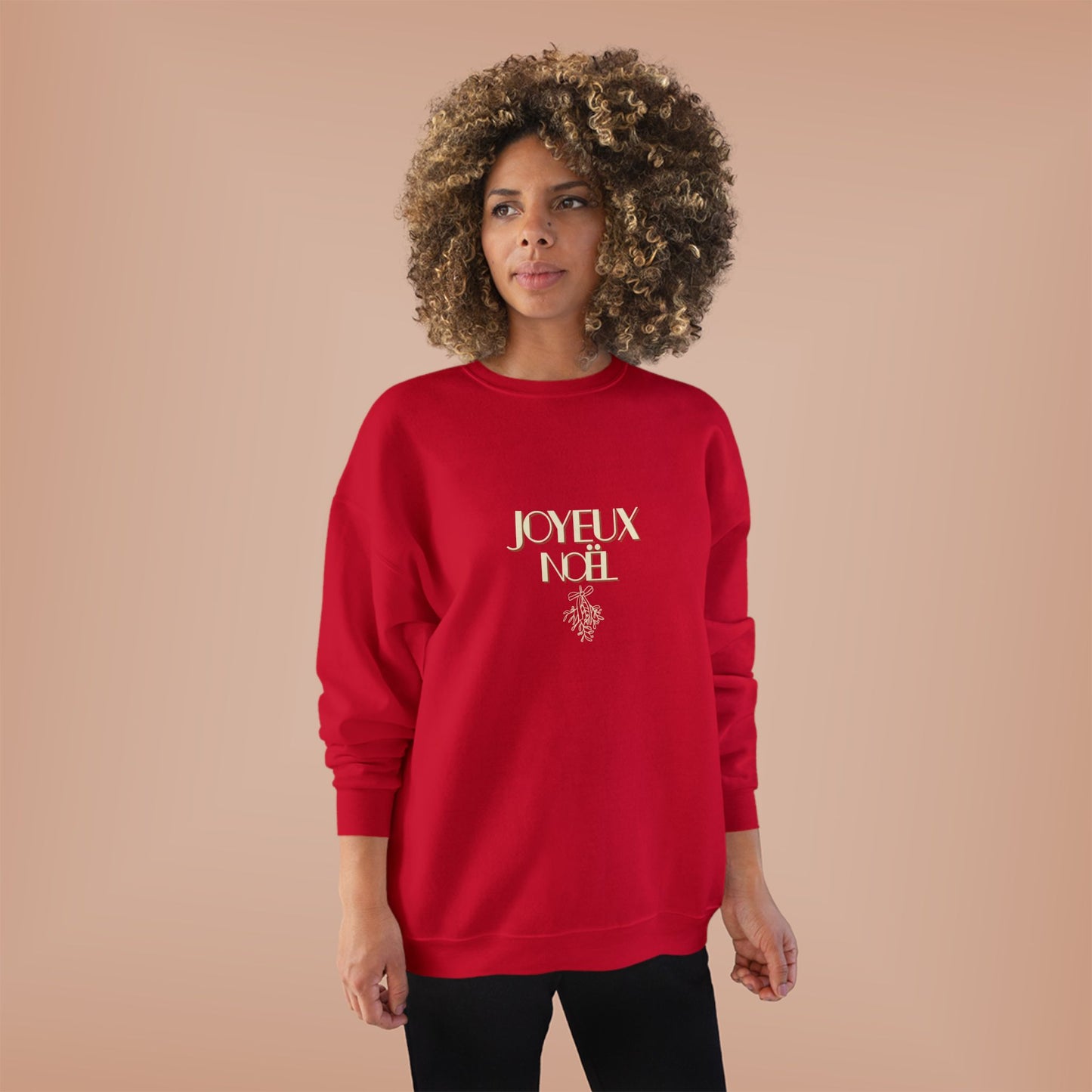 Person wearing a red sweatshirt with 'JOYEUX NOEL' text on a beige background