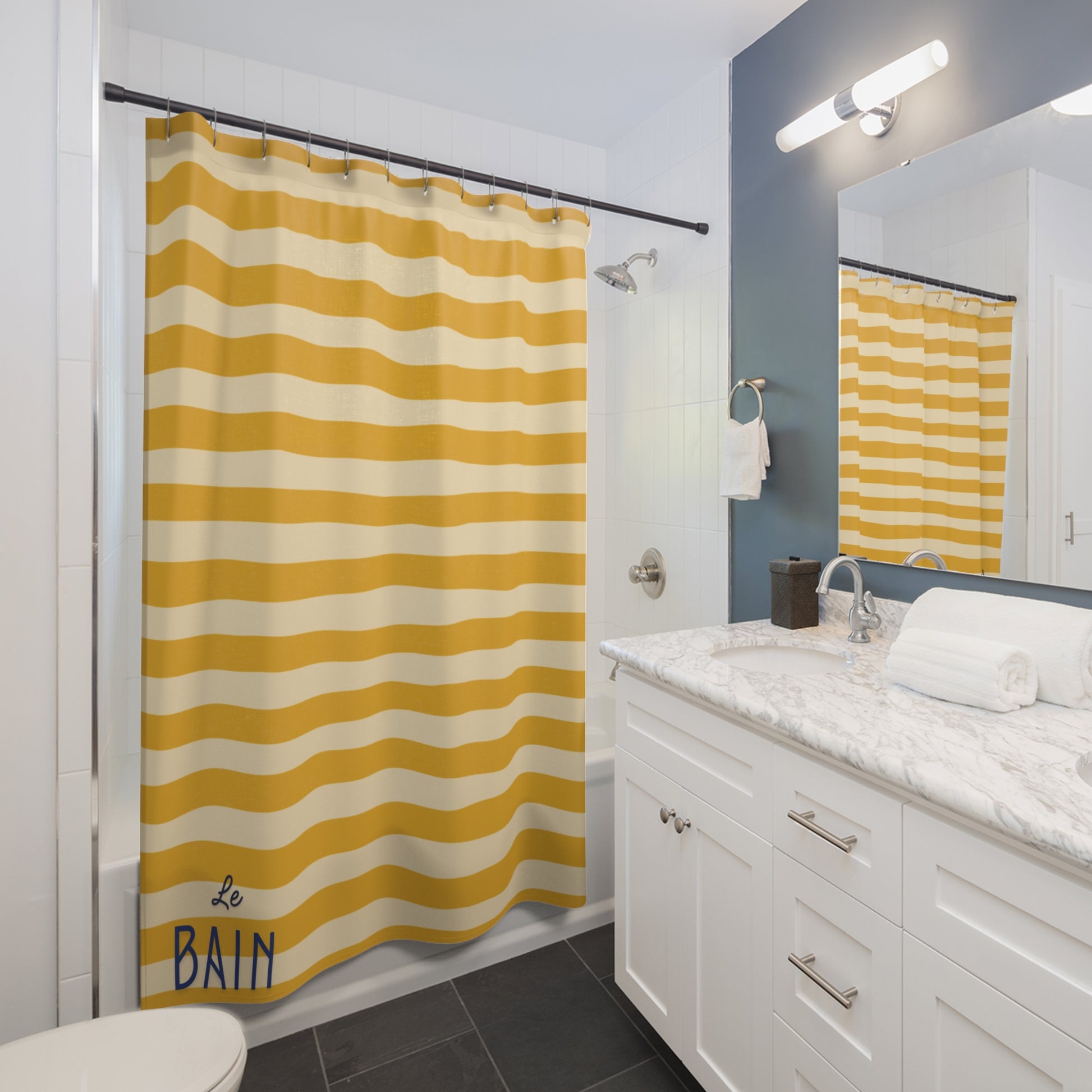 Bathroom with yellow and white striped shower curtain labeled 'Le Bain', white vanity, and mirror.