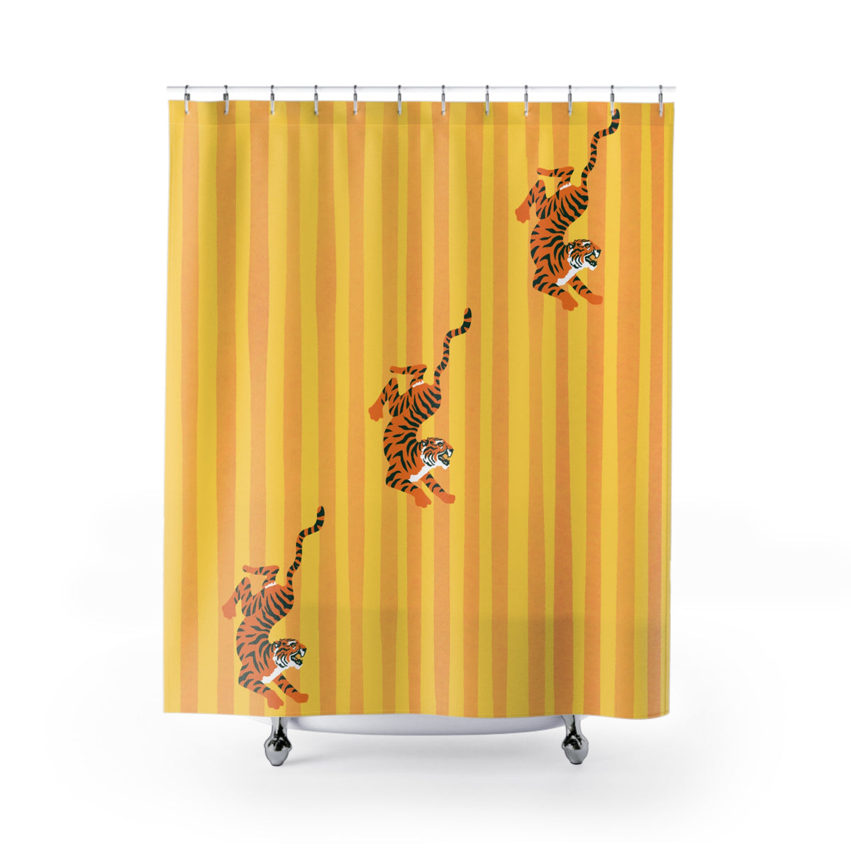 A yellow shower curtain with vertical orange stripes and three cartoon tigers walking diagonally across it, shown hanging over a white bathtub against a white background.