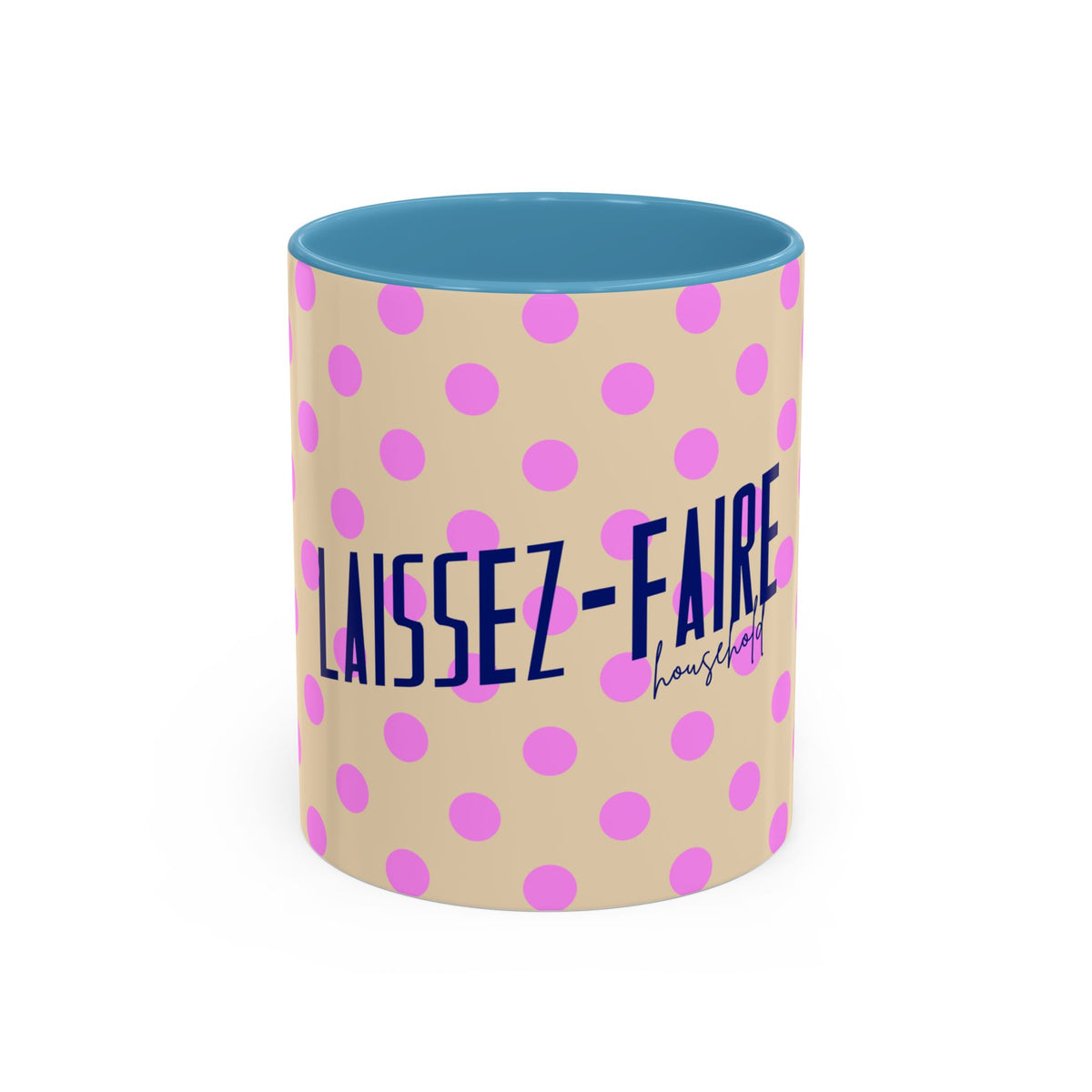 A ceramic mug with a beige exterior patterned with pink polka dots, featuring the French text 'LAISSEZ-FAIRE' in dark blue and a small 'household' script underneath. The interior of the mug is a solid light blue, set against a clean white background.