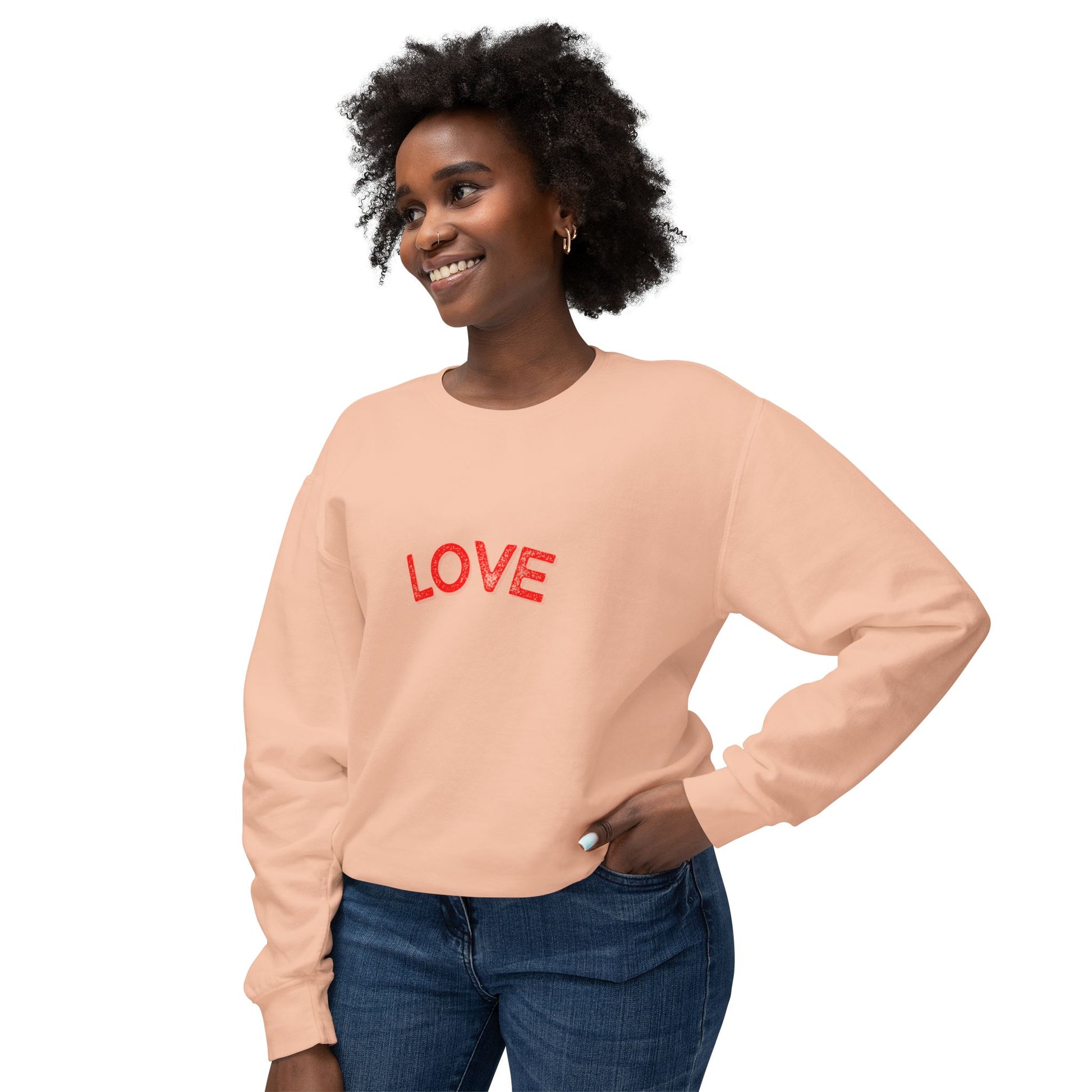 Woman wearing a peach sweatshirt with 'LOVE' in red text on a white background