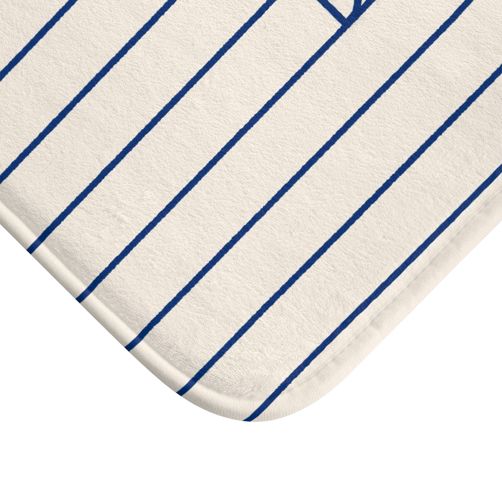 A close-up of a white or off-white fabric product with thin, evenly spaced blue pinstripes, showing a rounded corner and part of a stitched edge.
