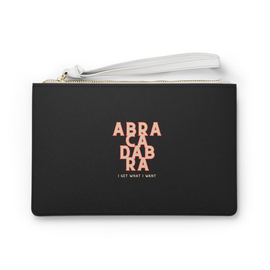 Black pouch with pink text 'ABRA CA DABA RA I GET WHAT I WANT' on a white background