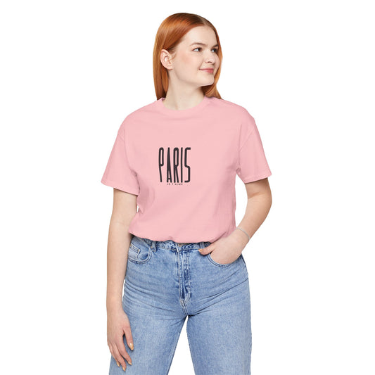 Person wearing a pink t-shirt with 'PARIS' text on a white background