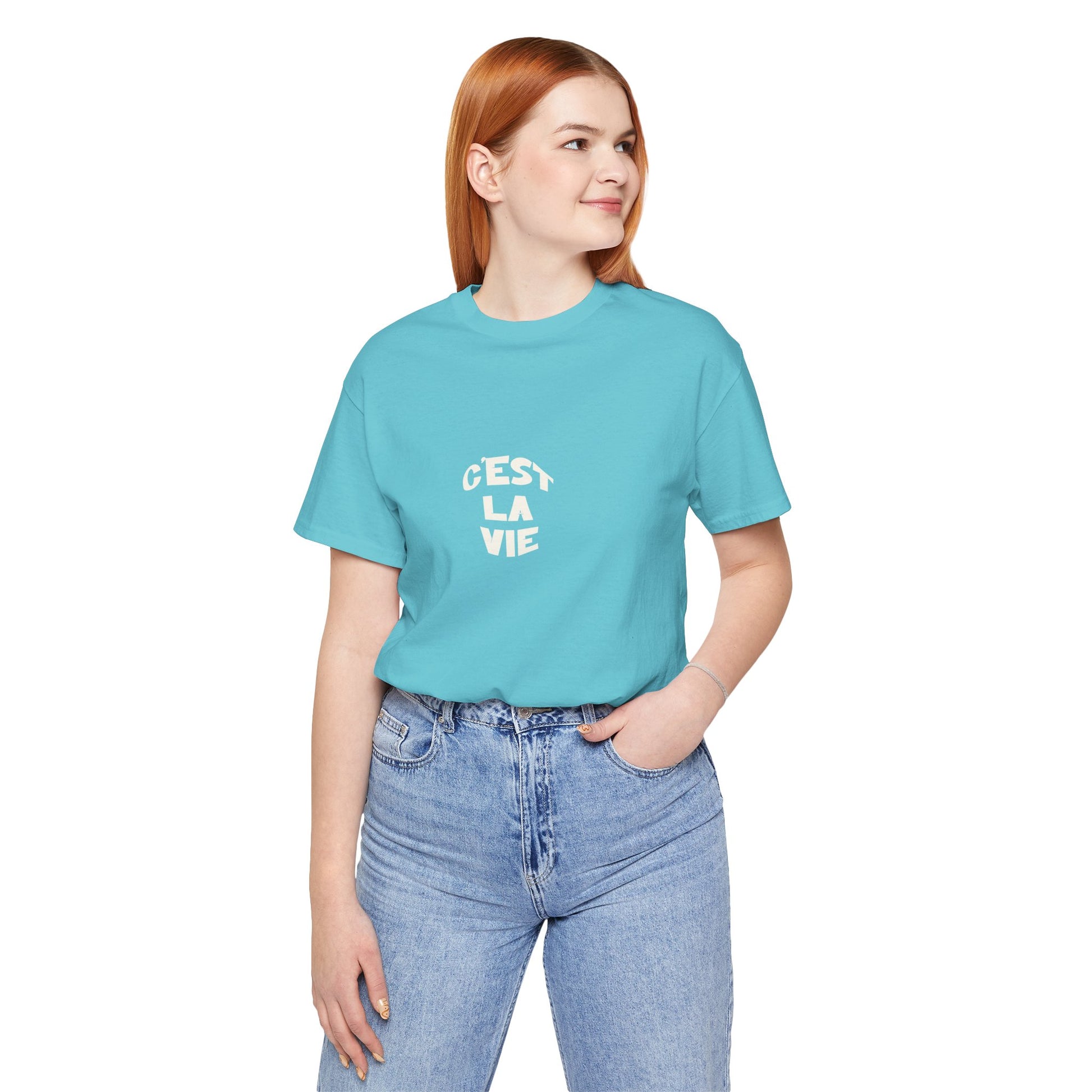 Person wearing a turquoise t-shirt with 'Cést La Vie' text on a white background