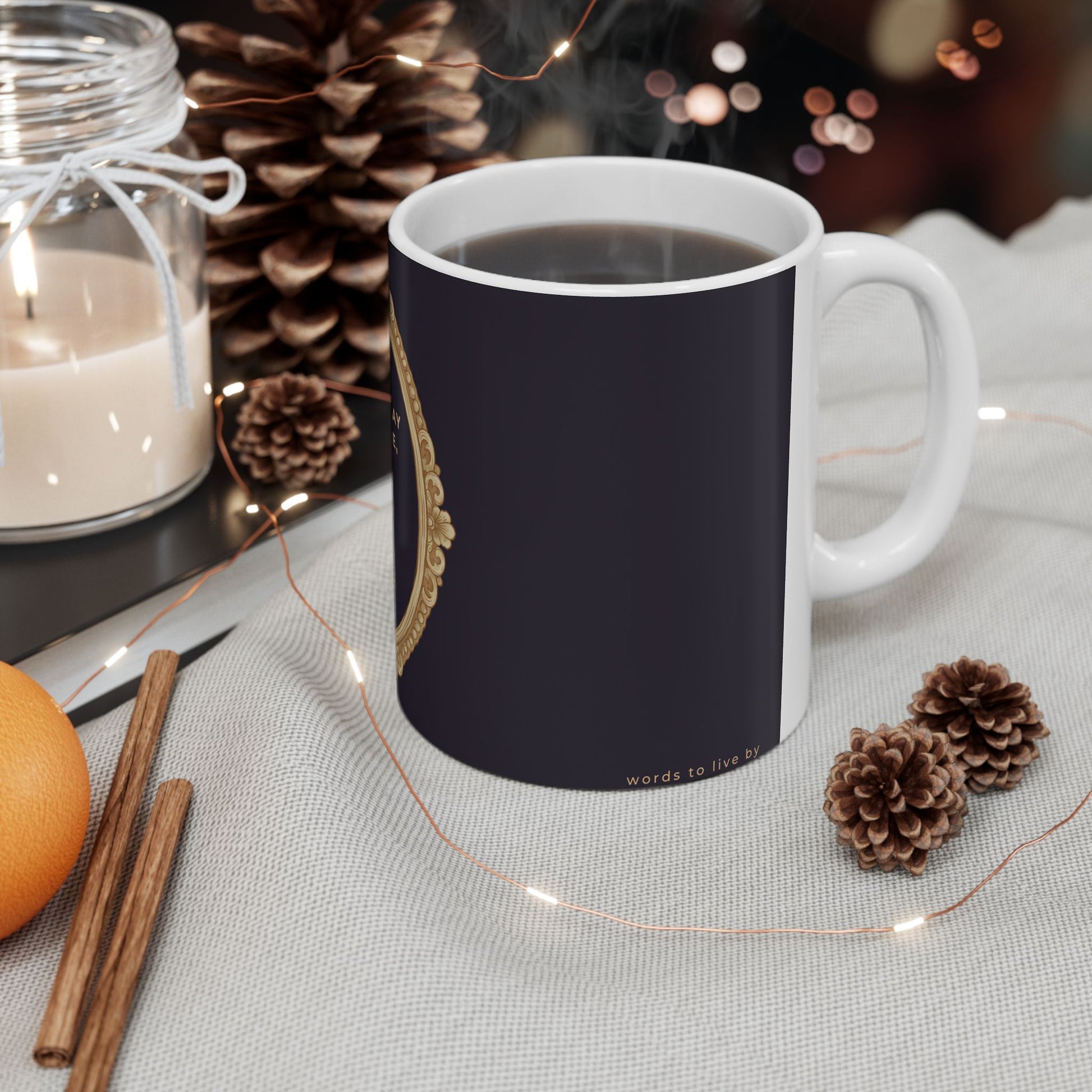Black mug with text and graphics on a table with decorative items