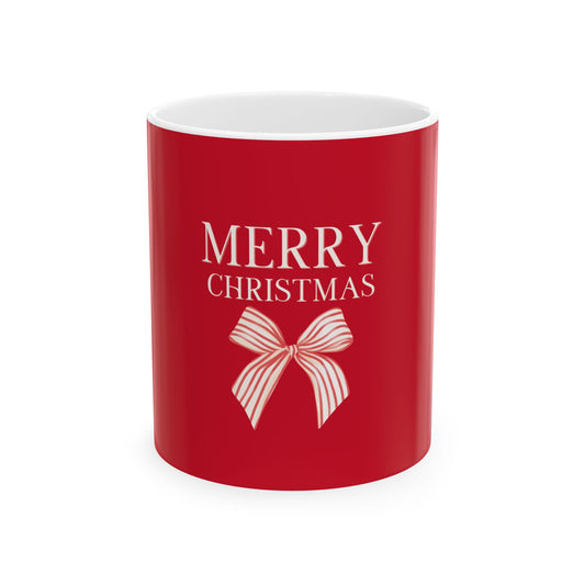 A red ceramic mug with a white interior, featuring the text 'MERRY CHRISTMAS' and a white striped bow graphic on the front, set against a plain white background.