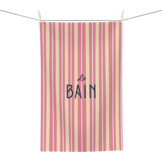 Striped towel with 'Le Bain' text hanging on a line
