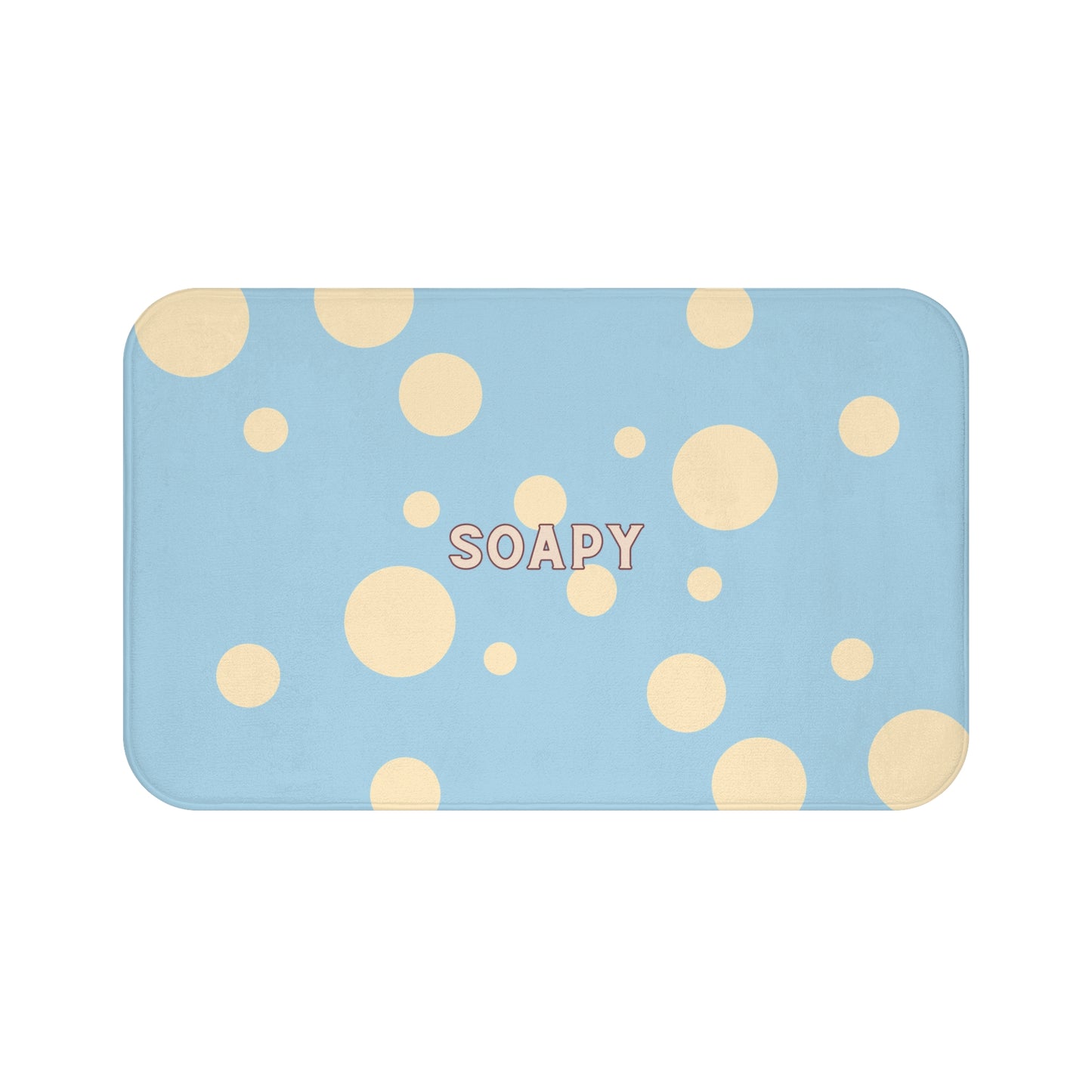 A rectangular bath mat with rounded corners, featuring a light blue background with scattered beige polka dots and the word 'SOAPY' printed in the center.