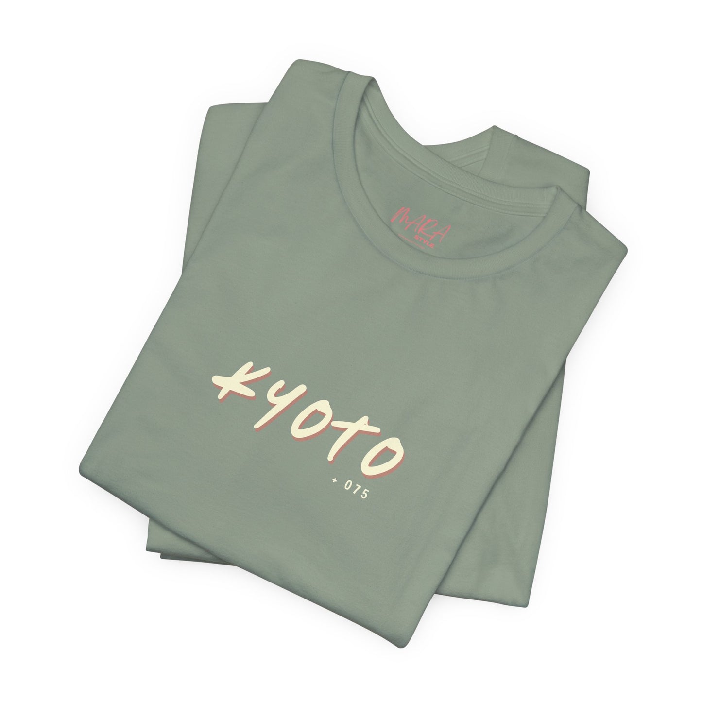 Folded sage t-shirt with 'Kyoto 075' text on a white background