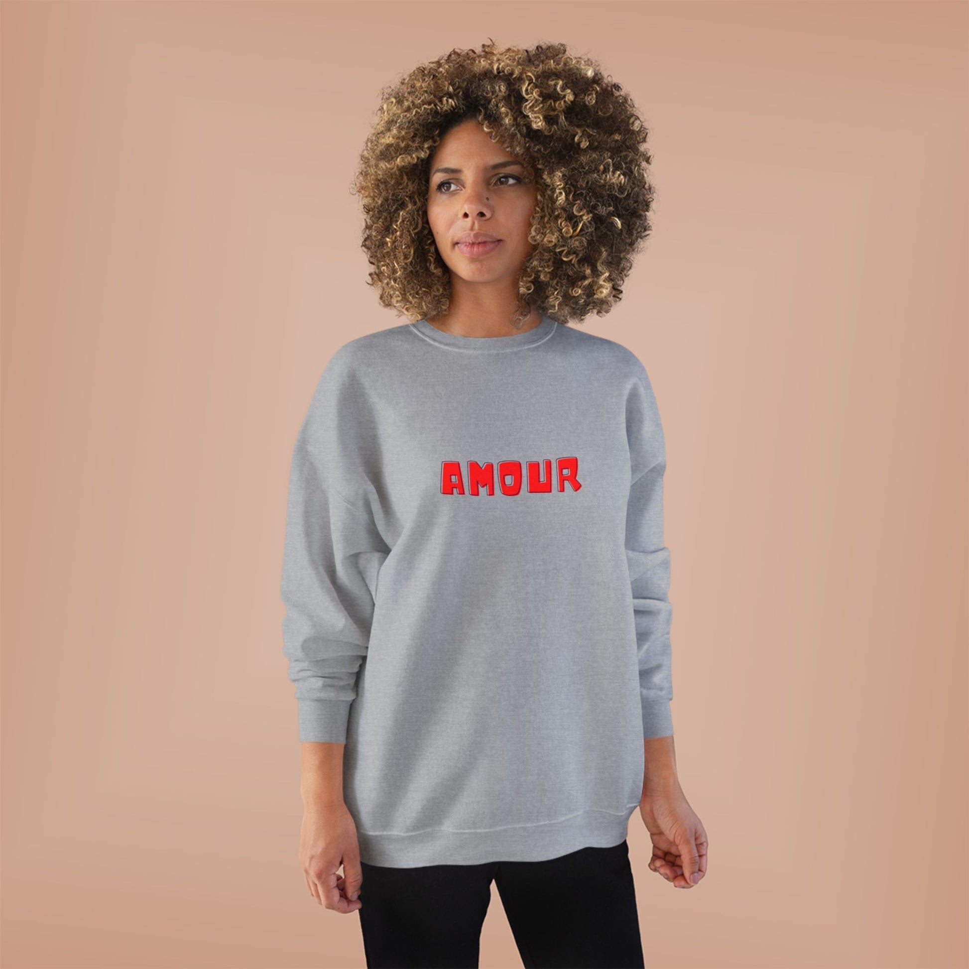 Person wearing a gray sweatshirt with 'AMOUR' printed in red on a beige background