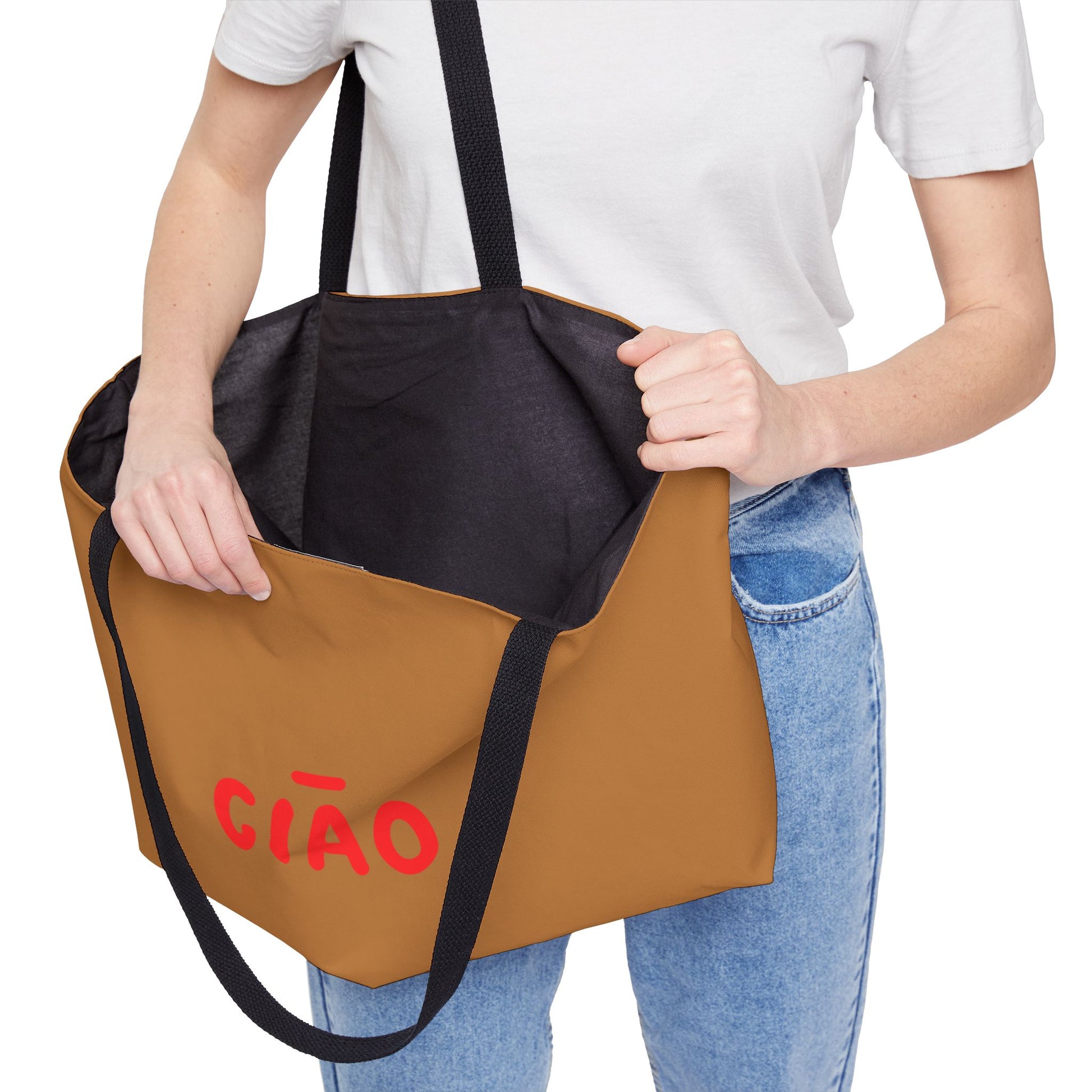 Person holding a brown and black tote bag with 'CIAO' written on it.