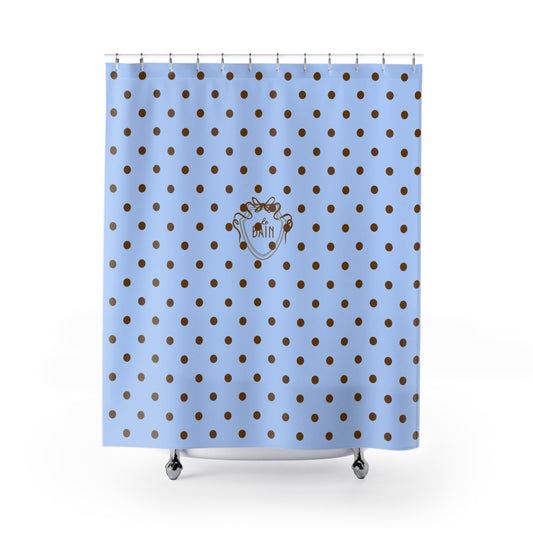 Shower curtain with blue background and brown polka dots featuring a logo.