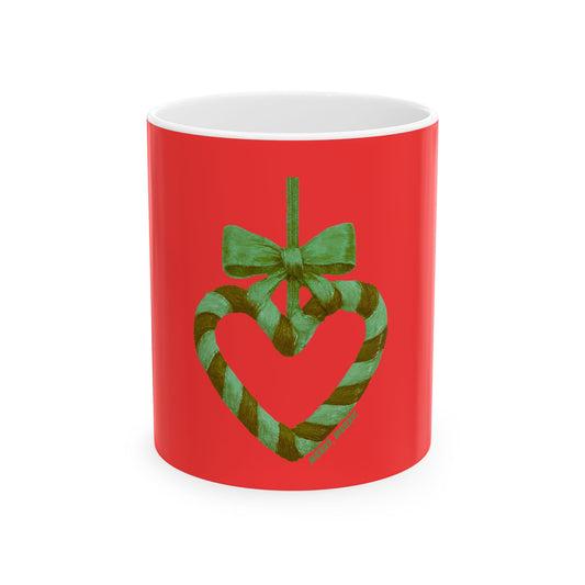 Red mug with a heart-shaped candy cane and green bow design on a white background