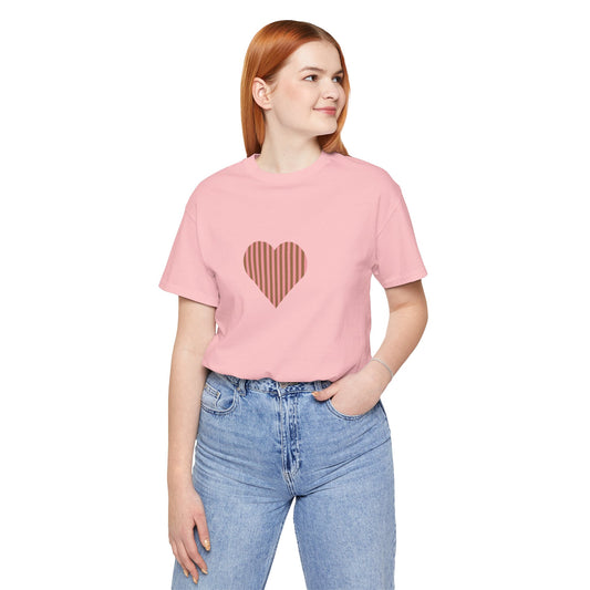 Person wearing a pink t-shirt with a heart design and blue jeans on a white background