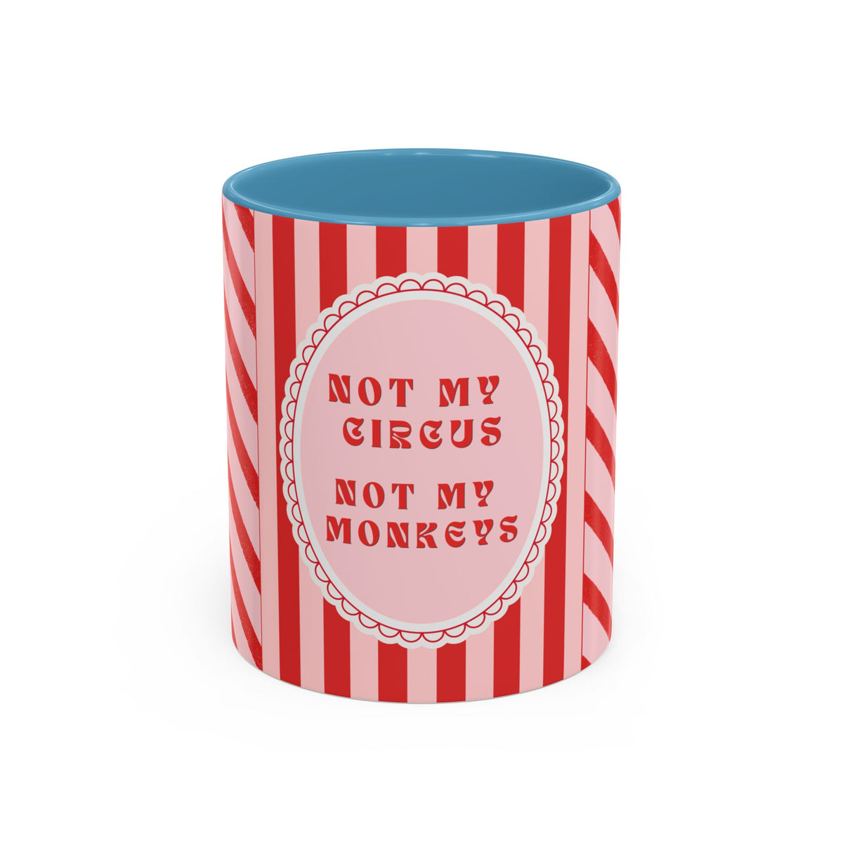 A ceramic mug with a red and pink striped design, featuring a central pink oval with the text 'NOT MY CIRCUS NOT MY MONKEYS' in red. The interior of the mug is light blue, shown against a plain white background.