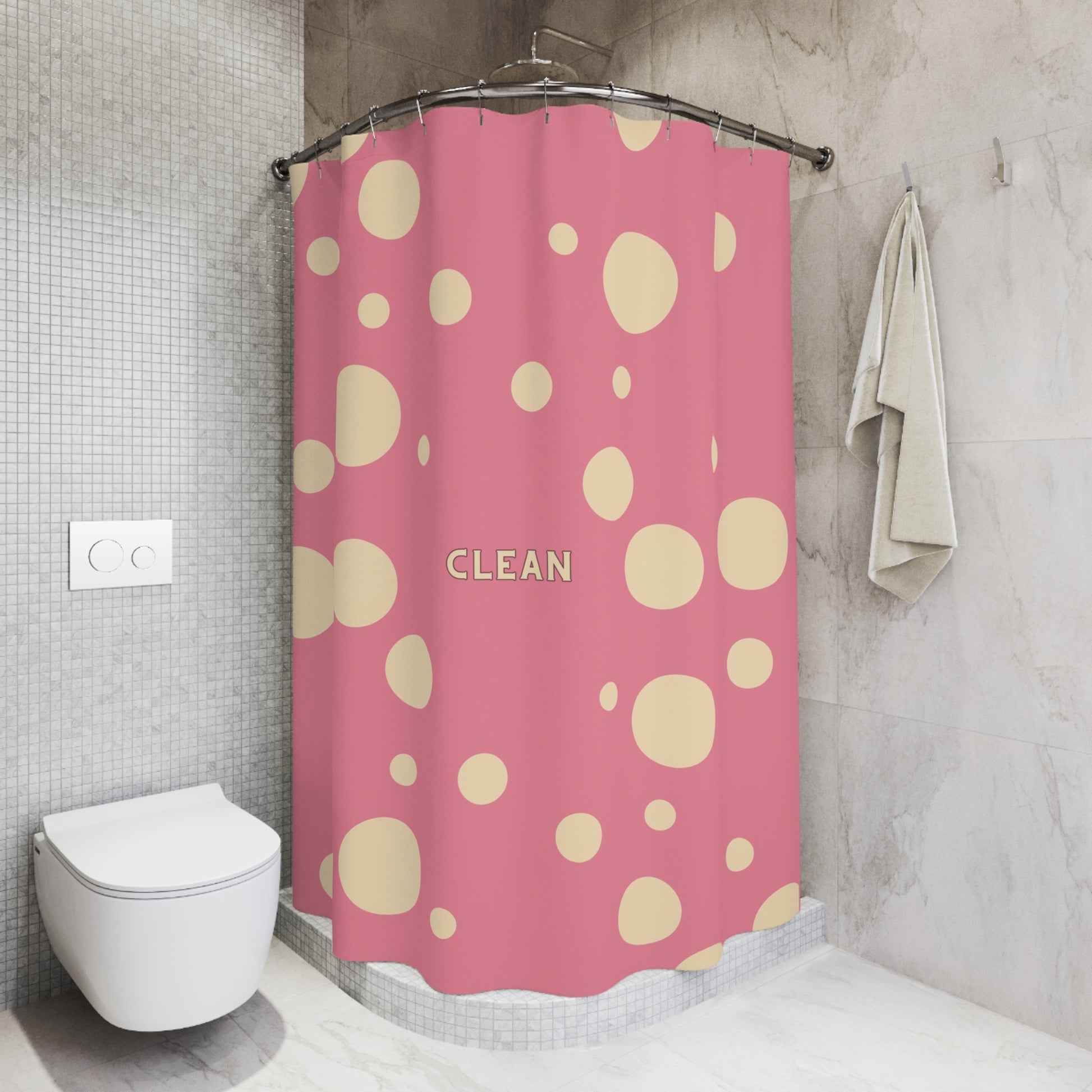 A pink shower curtain with beige polka dots and the word 'CLEAN' printed in the center, hanging in a modern tiled bathroom next to a toilet and a towel.
