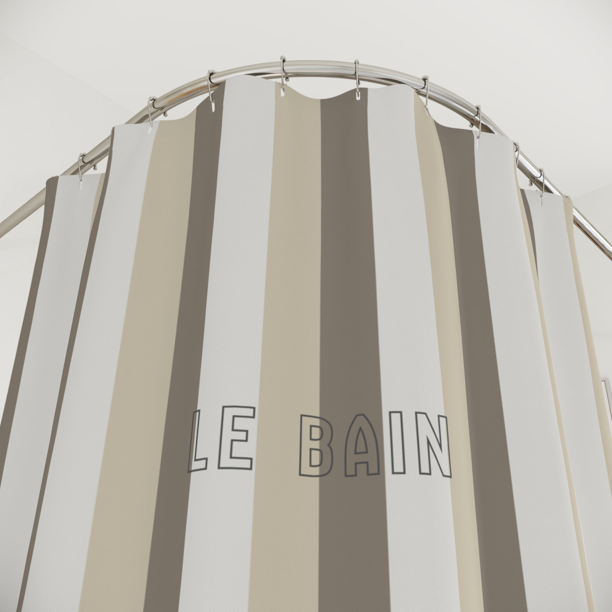 Striped shower curtain with 'LE BAIN' text on a neutral background