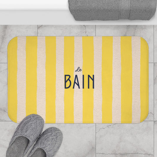 Striped bath mat with 'Le Bain' text on a bathroom floor.