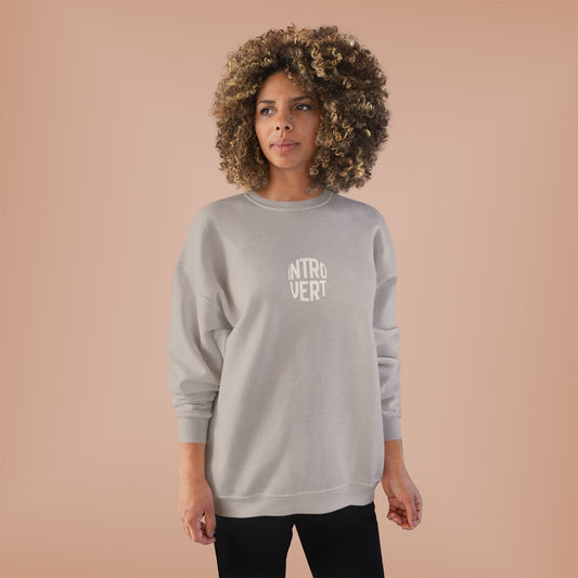 Person wearing a gray sweatshirt with 'INTROVERT' text on a beige background
