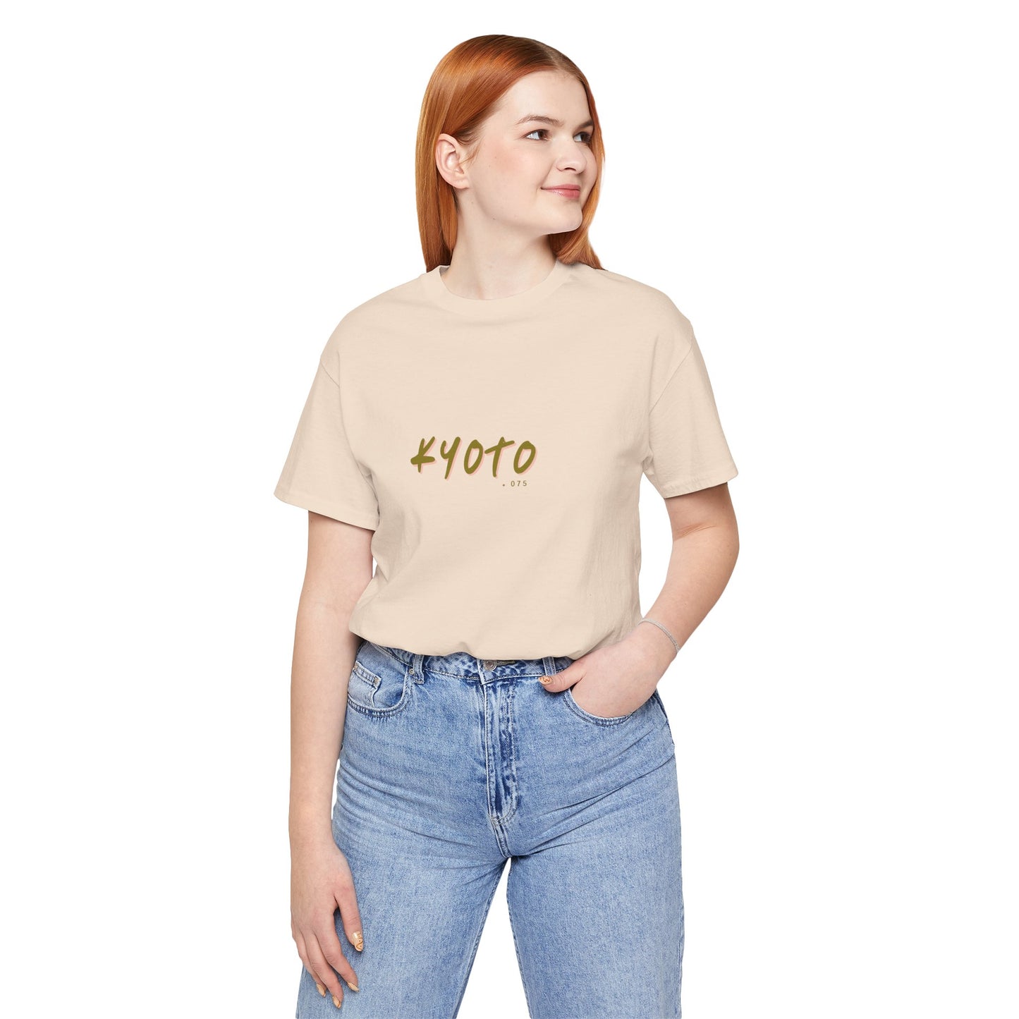 Person wearing a beige t-shirt with 'KYOTO' text and blue jeans on a white background