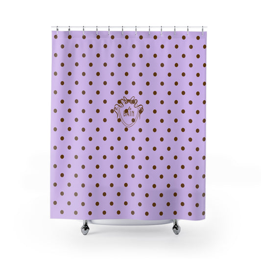 Purple shower curtain with gold polka dots and a logo on a white background