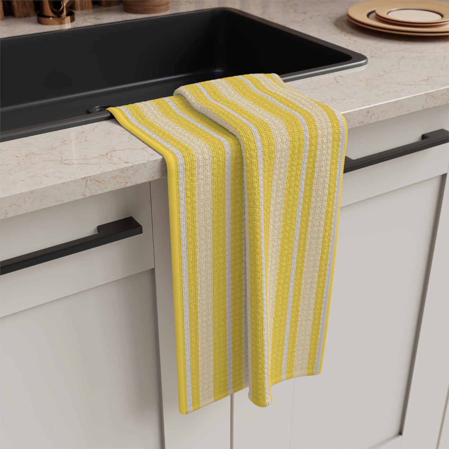 Yellow striped towel hanging on a kitchen cabinet next to a black sink.