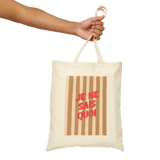 Tote bag with 'JE NE SAIS QUOI' text held by a hand on a white background