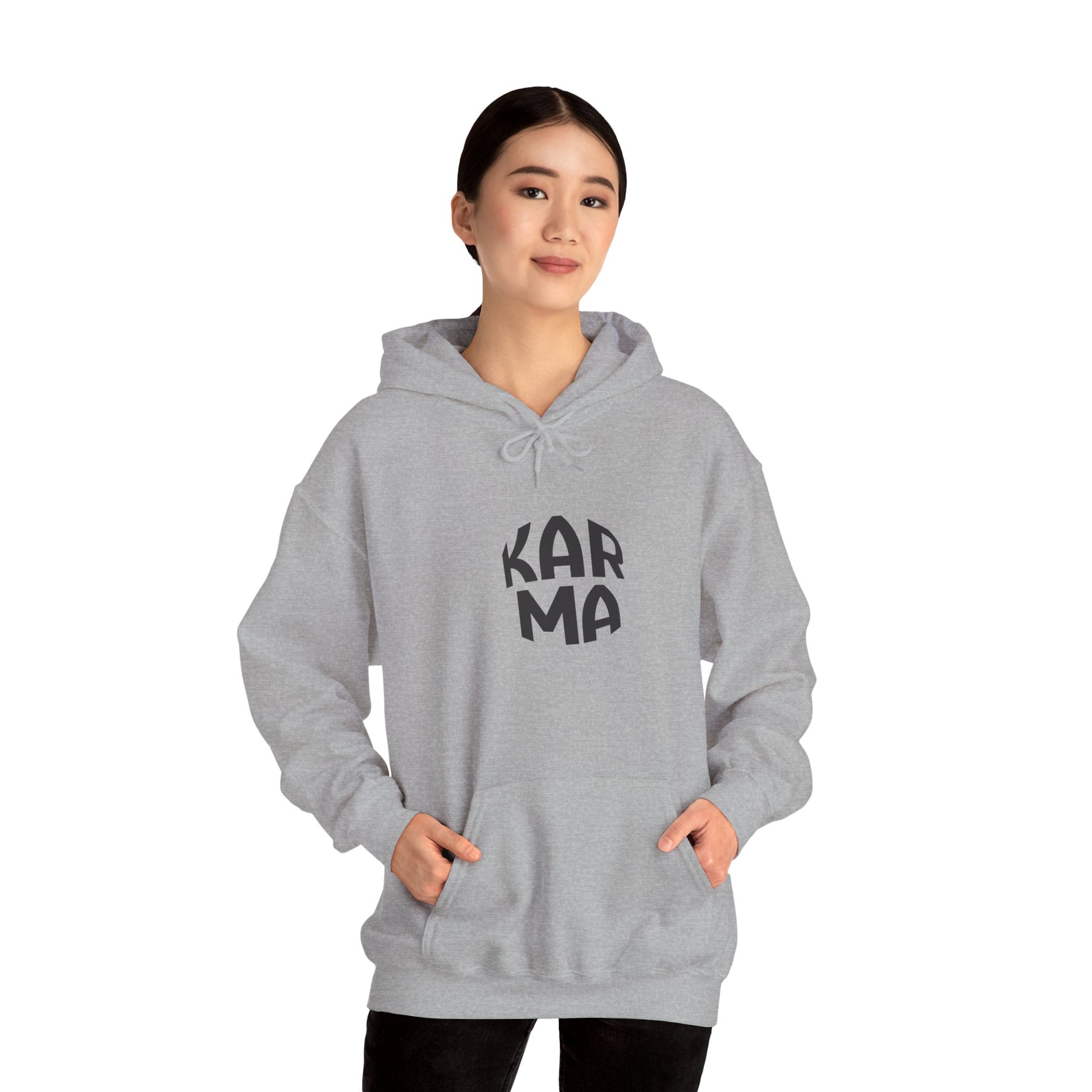 Person wearing a gray hoodie with 'Karma' text on a white background