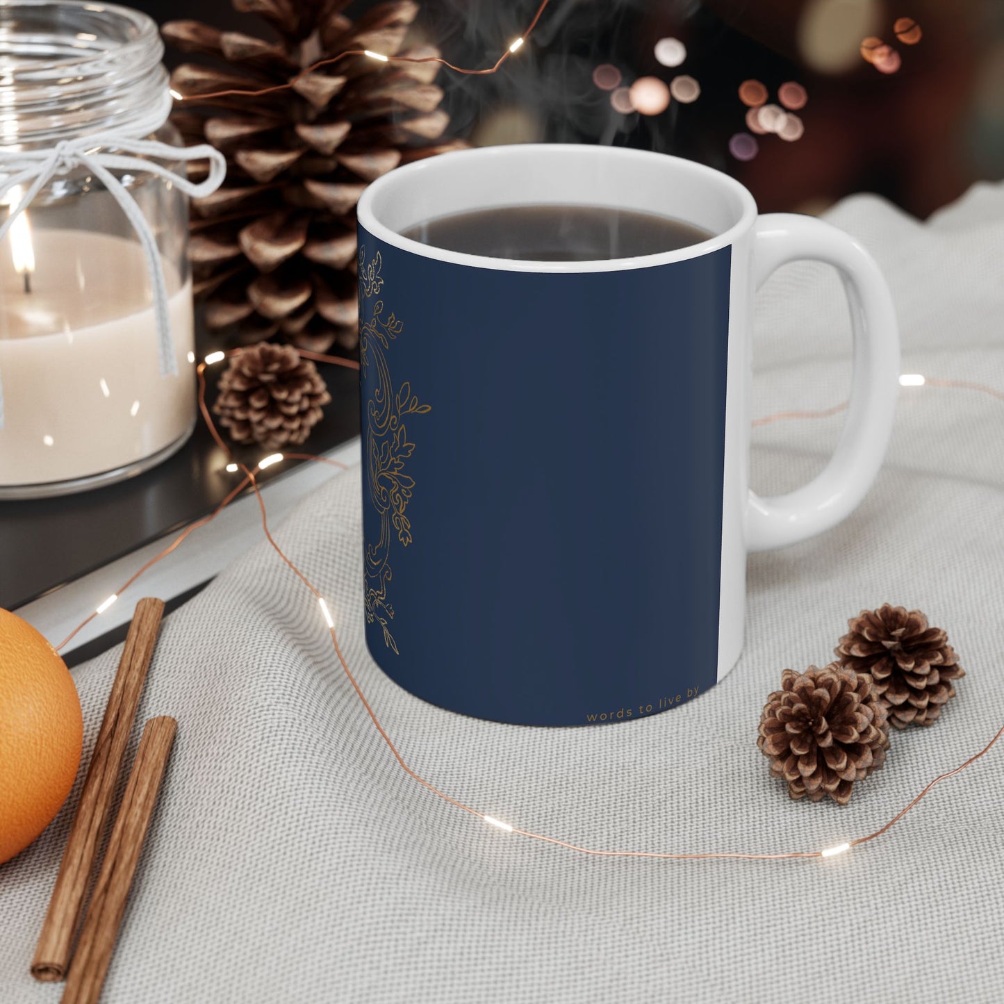 Navy blue mug with white handle on a table with decorative items
