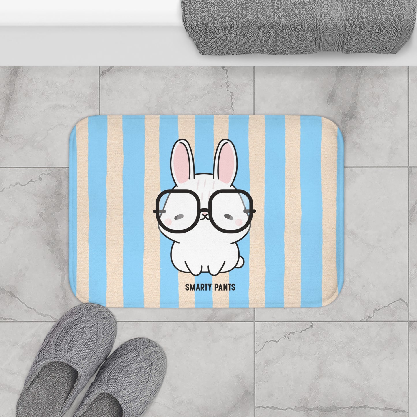 Striped bath mat with a cartoon bunny wearing glasses on a bathroom floor.