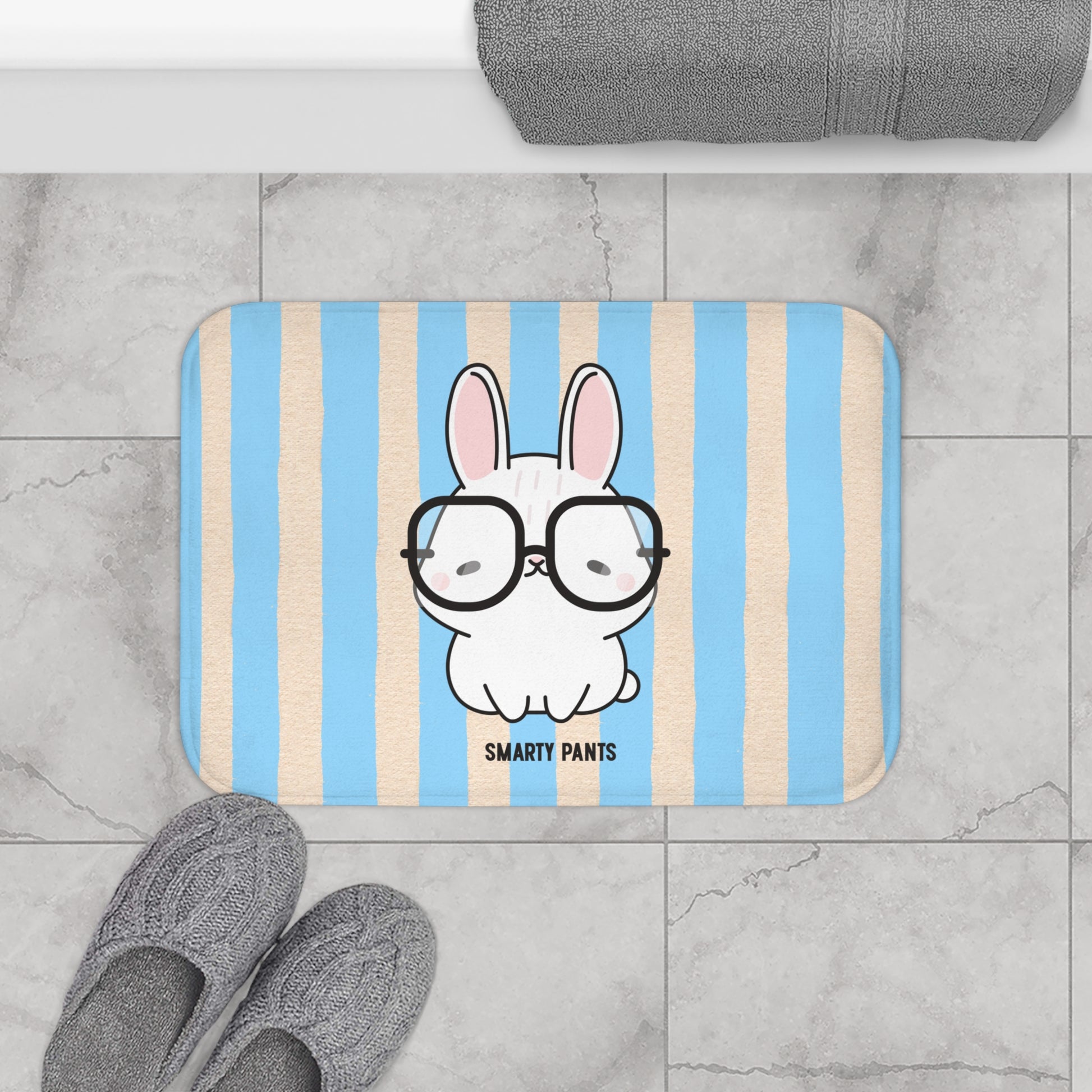 Striped bath mat with a cartoon bunny wearing glasses on a bathroom floor.