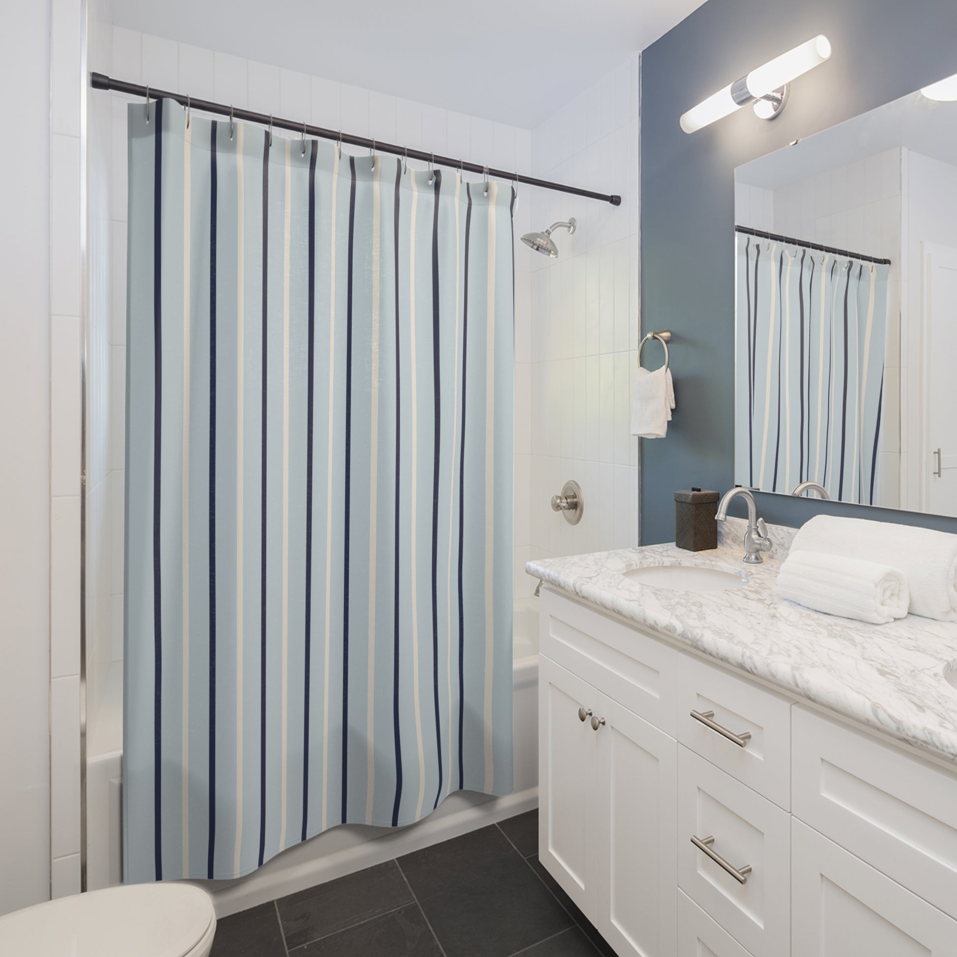 Bathroom with striped shower curtain, white vanity, and mirror.