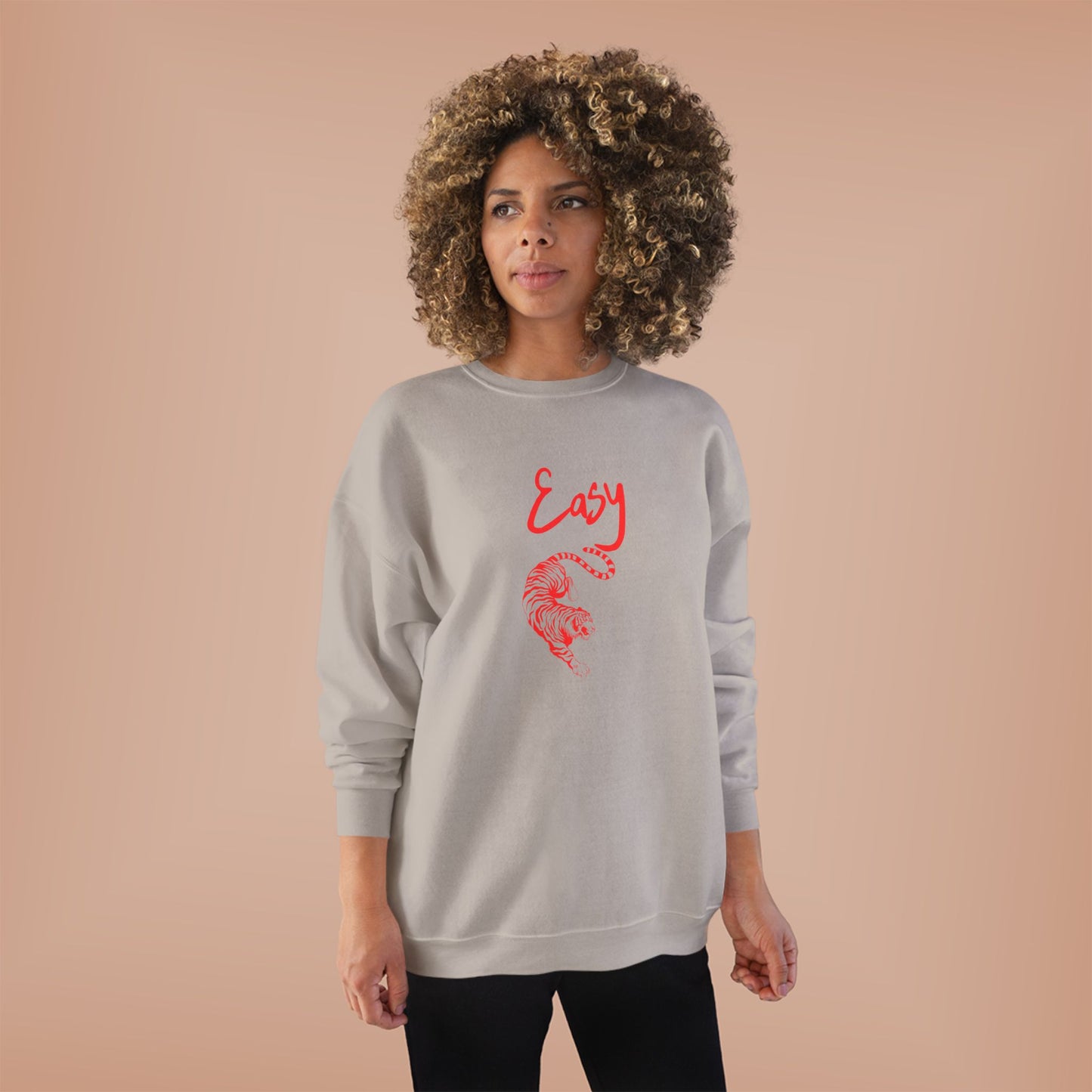 Woman wearing a gray EASY TIGER sweatshirt with red text and design on a beige background