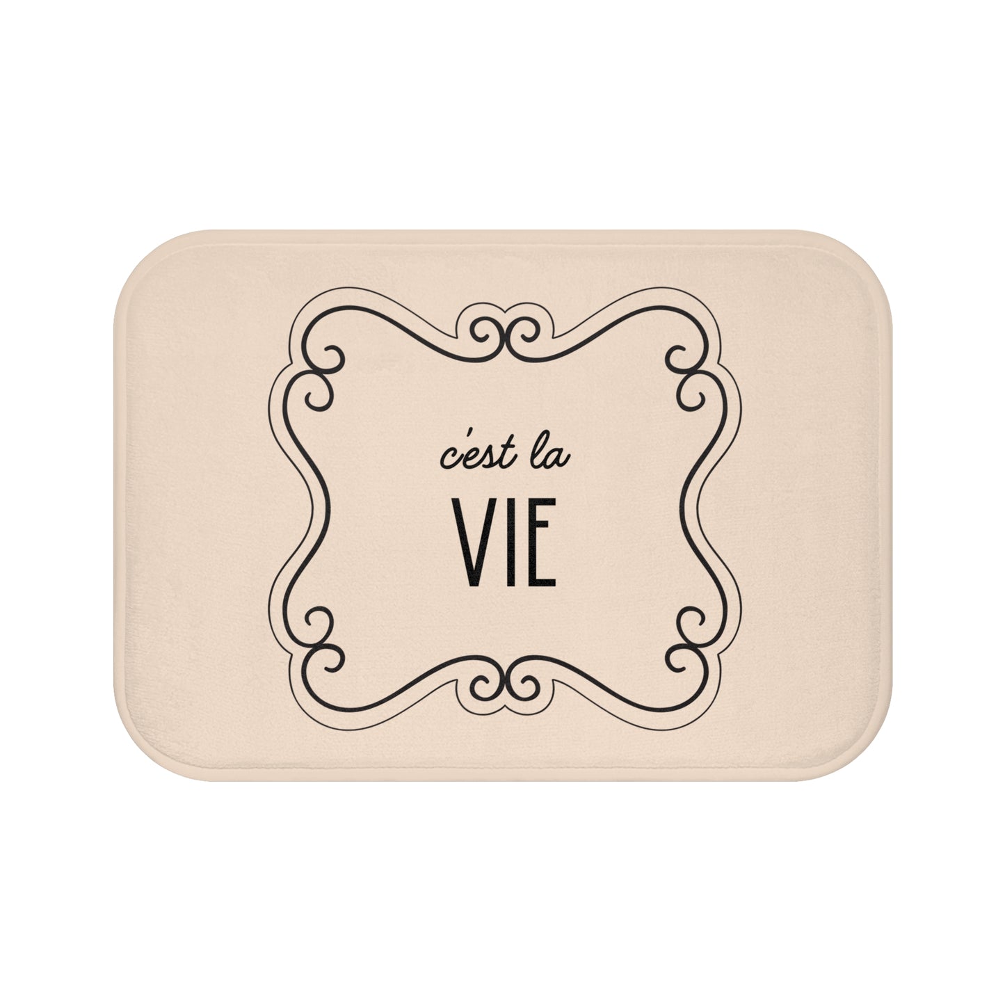 Beige bath mat with 'c'est la Vie' text and decorative frame on a white background