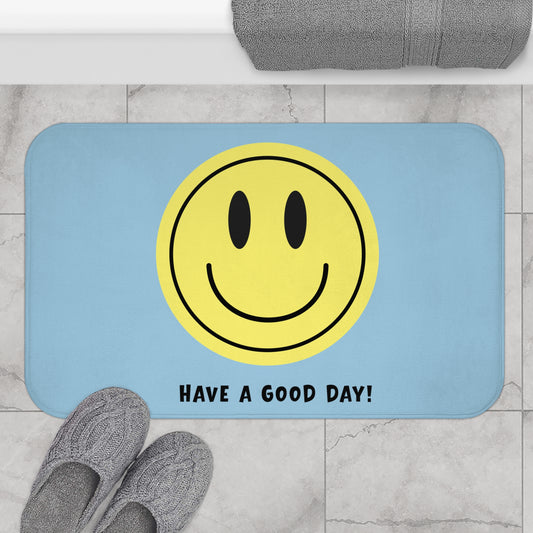 Bath mat with smiley face and 'Have a Good Day!' text on a bathroom floor.