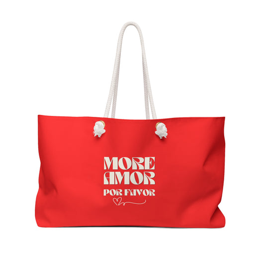 Red tote bag with white handles and 'More Amor Por Favor' text on a white background