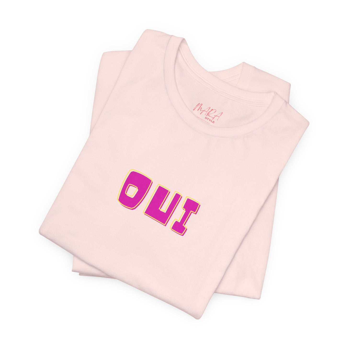 Folded pink tank top with 'OUI' text on a white background