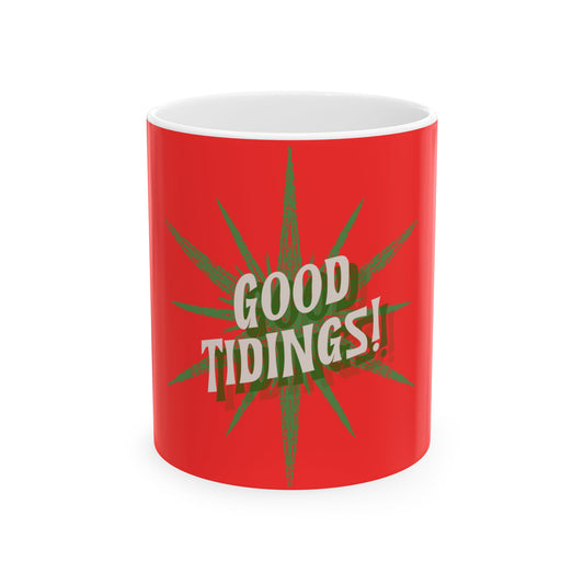 A red ceramic mug with a white interior, featuring a green starburst graphic and the text 'GOOD TIDINGS!' in white with a dark outline, set against a plain white background.