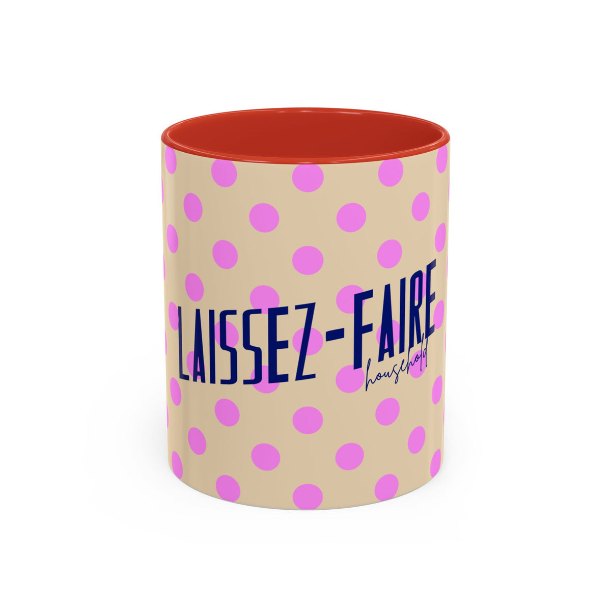 A ceramic mug with a beige exterior patterned with pink polka dots, featuring the French text 'LAISSEZ-FAIRE' in dark blue and a small 'household' signature below. The interior of the mug is a solid orange-red color, shown against a plain white background.