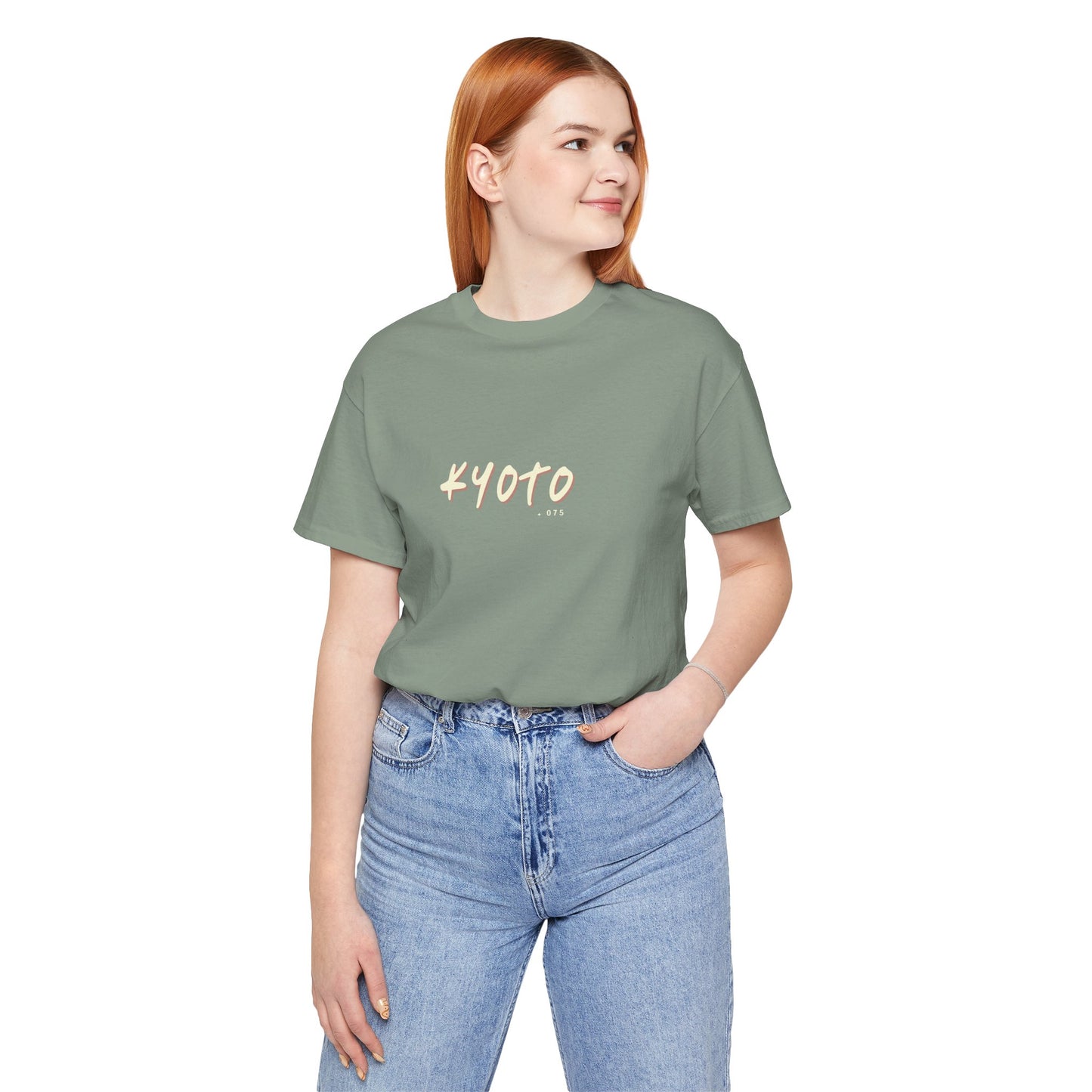 Person wearing a green t-shirt with 'KYOTO' text and blue jeans on a white background
