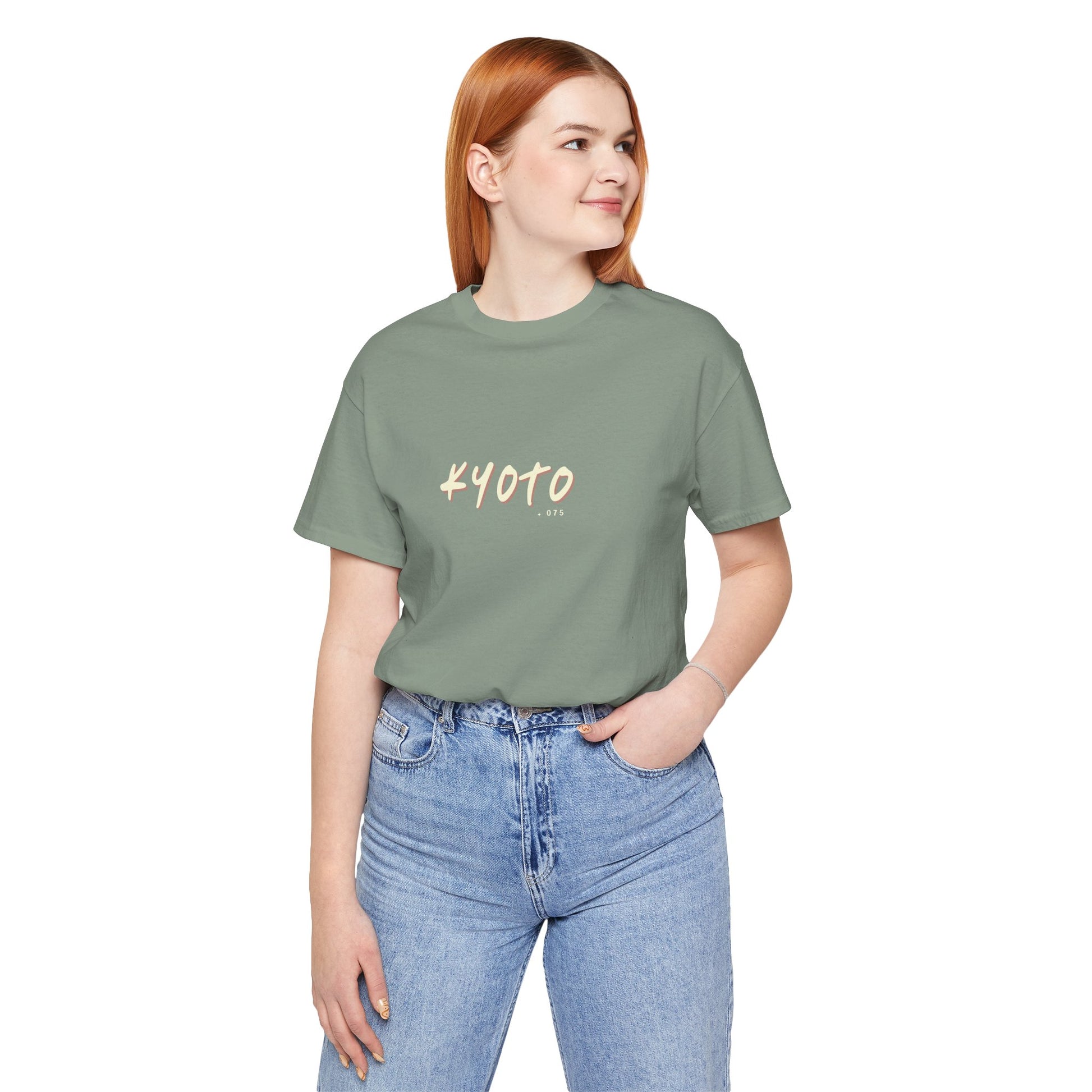 Person wearing a green t-shirt with 'KYOTO' text and blue jeans on a white background