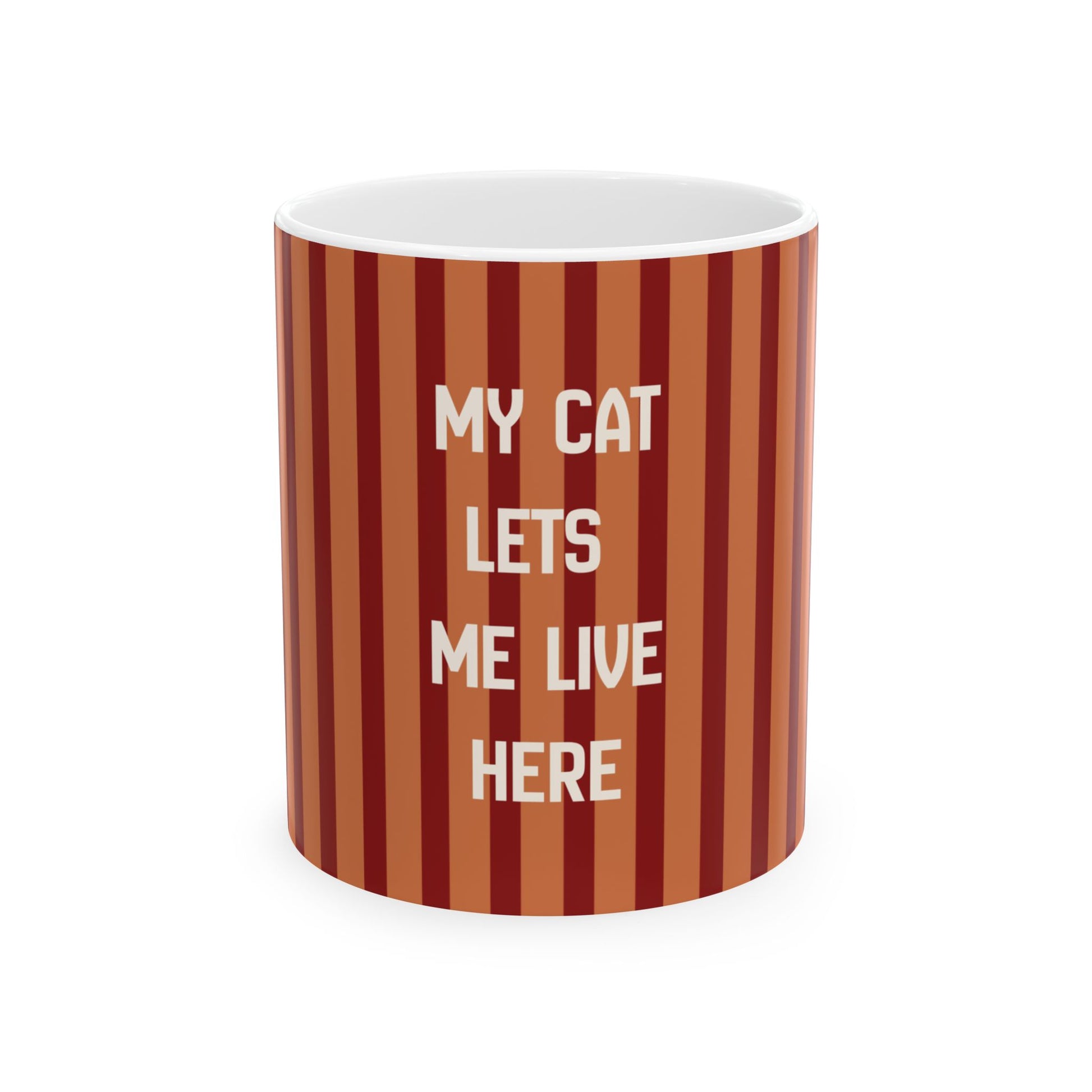 A cylindrical mug with a vertical striped pattern in shades of rust, terracotta, and dark red, featuring the text 'MY CAT LETS ME LIVE HERE' in white capital letters. The mug is shown on a clean white background.