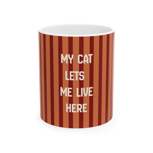 A cylindrical mug with a vertical striped pattern in shades of rust, terracotta, and dark red, featuring the text 'MY CAT LETS ME LIVE HERE' in white capital letters. The mug is shown on a clean white background.