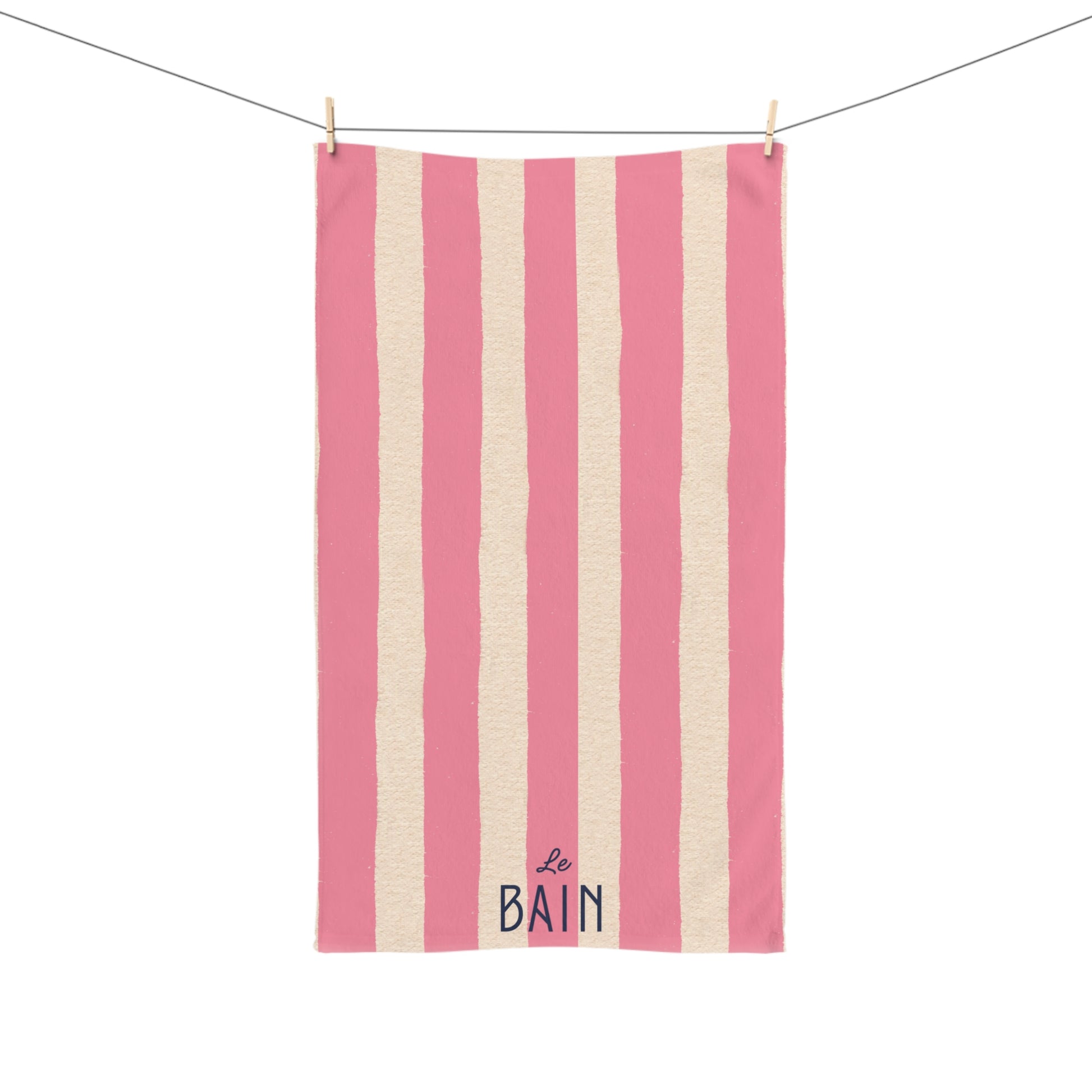 Striped towel with pink and white vertical stripes and 'Le Bain' text on a white background