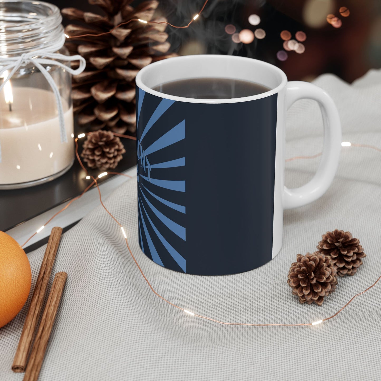 Navy blue mug with white handle on a table with decorative items