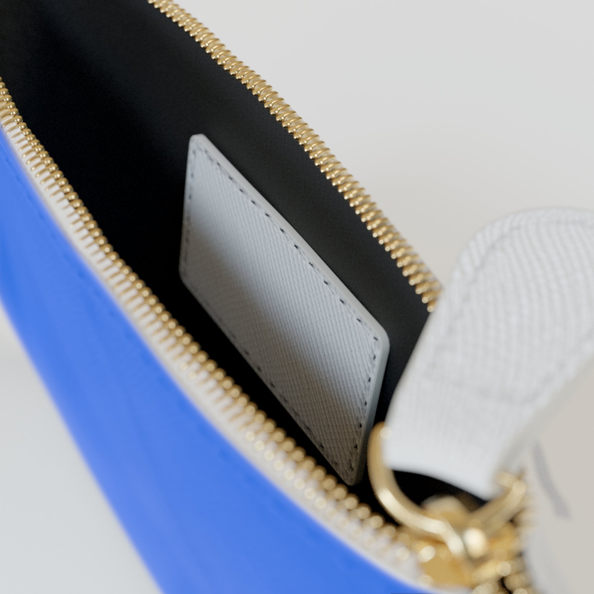 Close-up of a blue bag with gold zipper and white interior